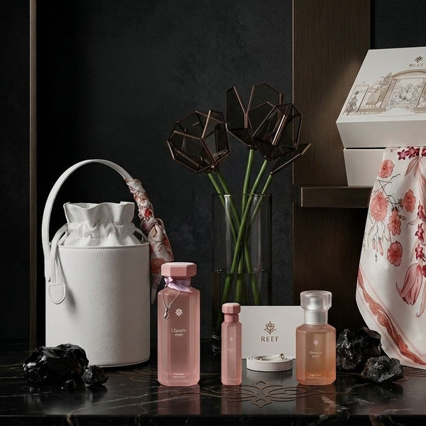 Cosmetic products and accessories on a dark surface with a decorative box in the background.
