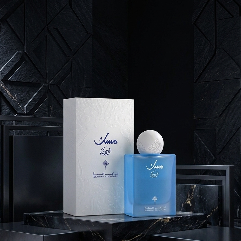 Blue perfume bottle and white box with 'Juice' branding on a dark textured background