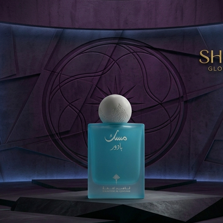 Blue perfume bottle with white cap on a dark background, featuring the 'SHE GLOW' brand.