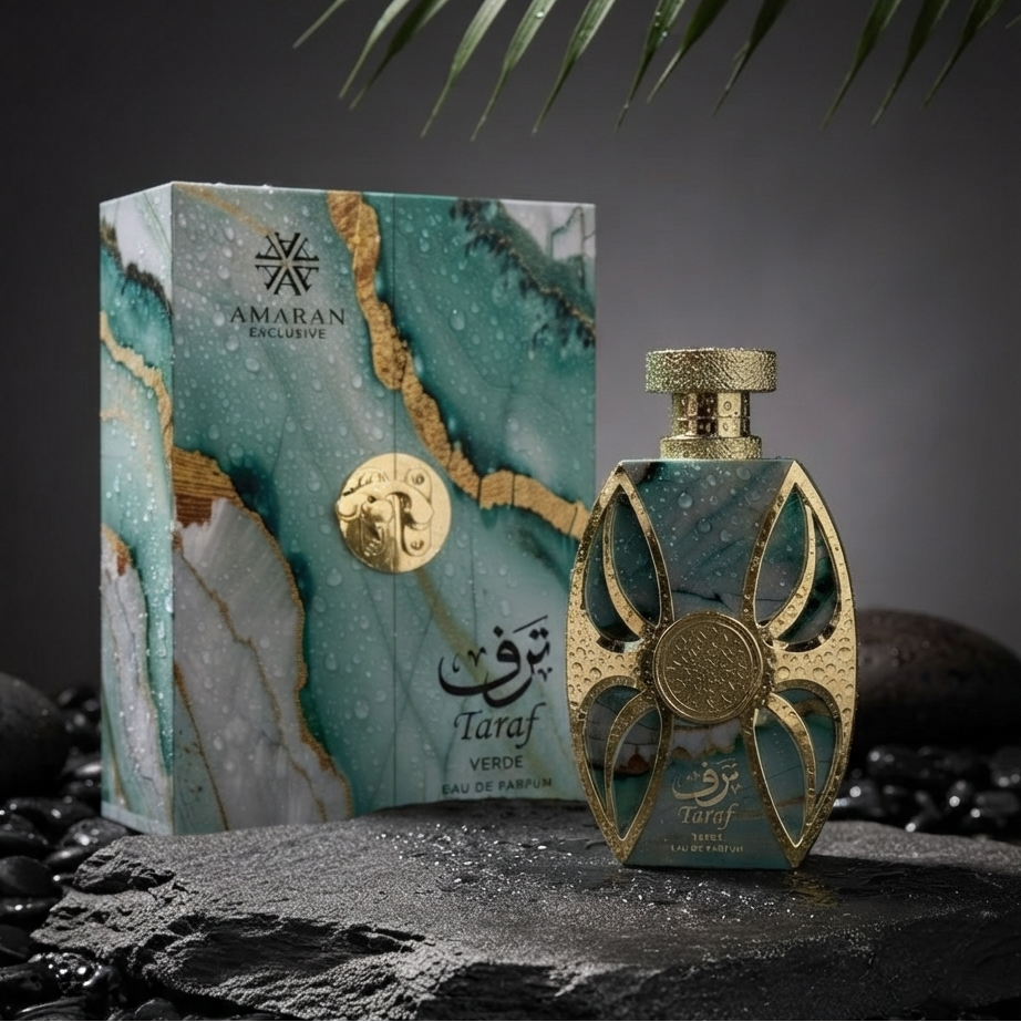 Amaran Taraf Eau de Parfum bottle and its matching marble-patterned box, styled on a dark stone surface with wet black pebbles and green palm leaves against a dark gray background. SHE GLOW 