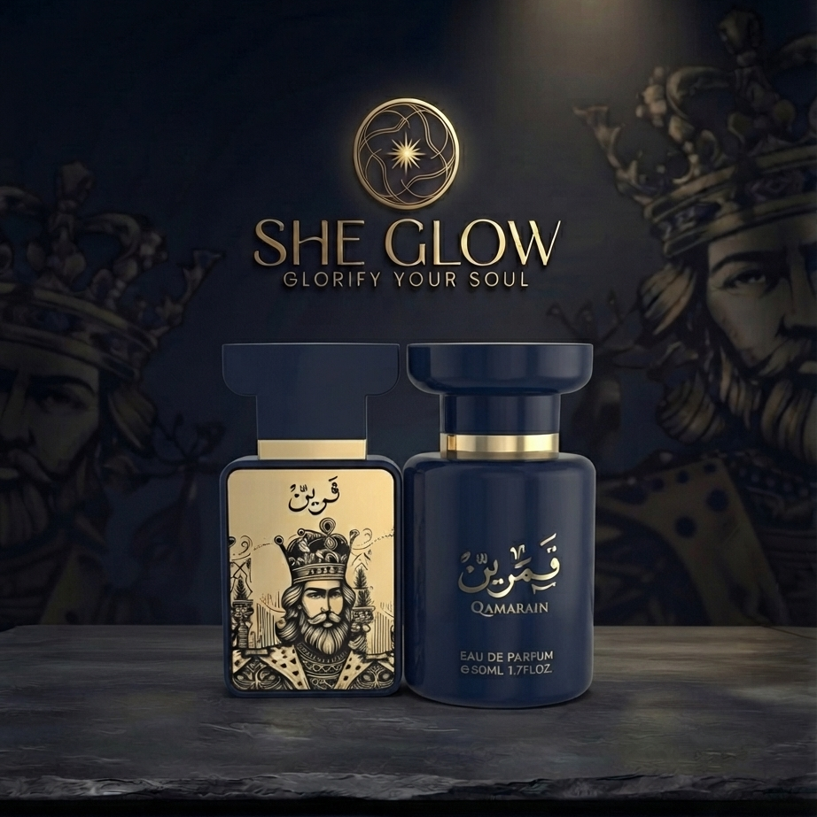 Two perfume bottles for Qamarain Eau de Parfum by She Glow, displayed on a dark stone surface against a dark background with gold lettering and crown illustrations.