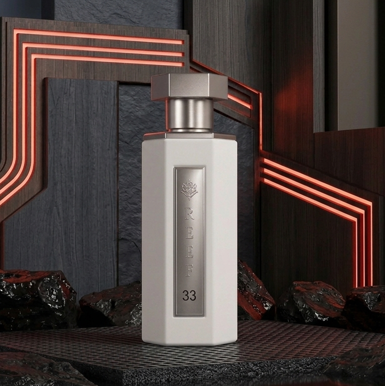 A modern rectangular white bottle with a metallic cap stands centered in a stylized dark studio setup with glowing red-orange geometric lines and black textured rocks behind it. SHE GLOW