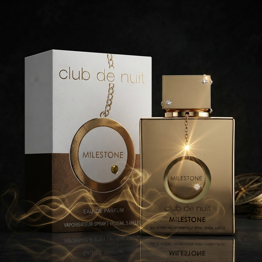 Club de Nuit Milestone Eau de Parfum bottle and its retail box, both in a metallic gold and white color scheme, displayed on a reflective black surface with stylized golden light effects. SHE GLOW