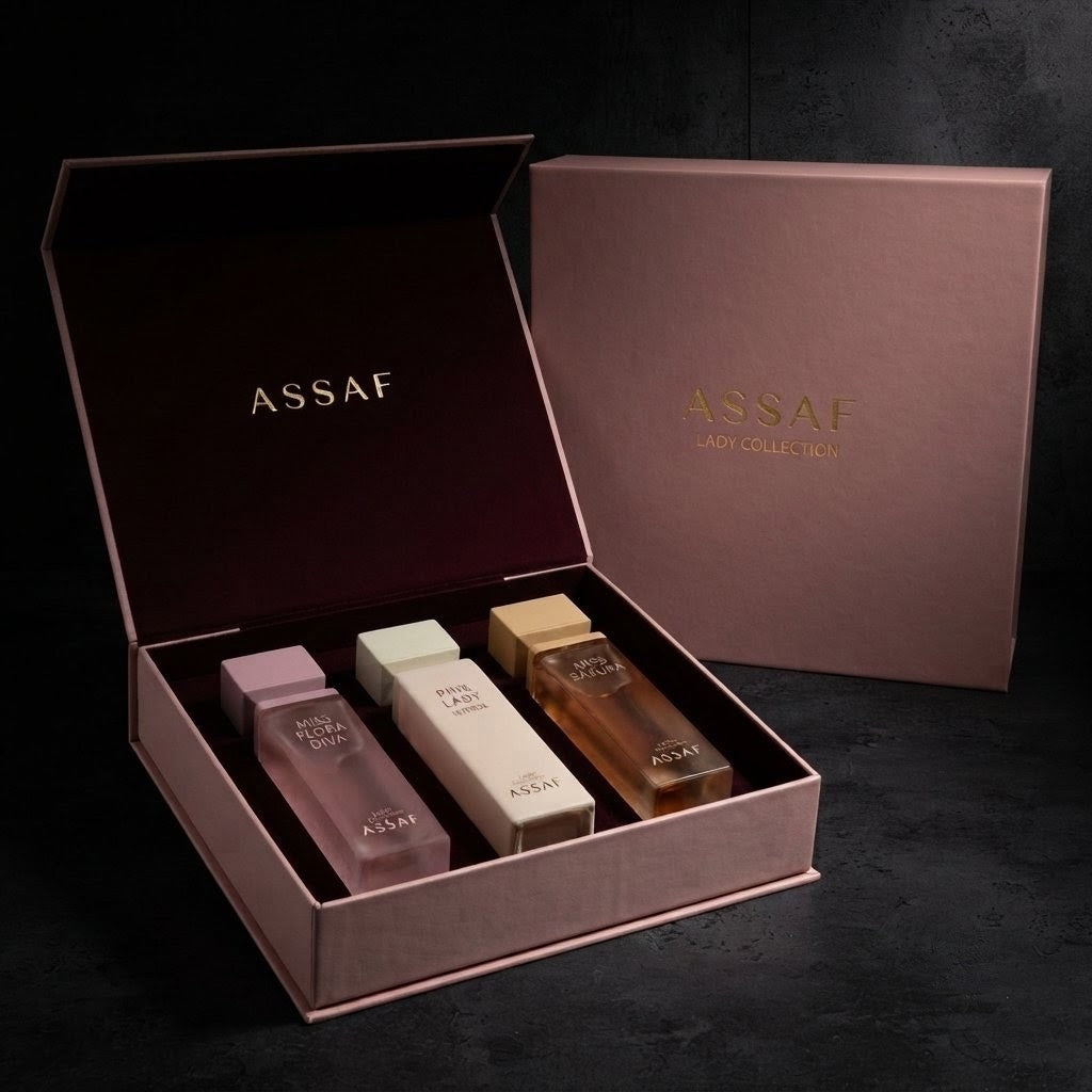 Assaf Lady Collection perfume gift set in a rose gold box, featuring three bottles of Assaf Rose Gold, Assaf White, and Assaf Gold fragrances, with the brand's outer box standing behind. SHE GLOW 