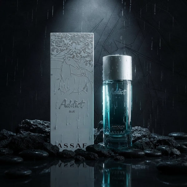 ASSAF Addict Blue cologne bottle and its packaging box, styled on wet rocks with rain and a spotlight effect. SHE GLOW