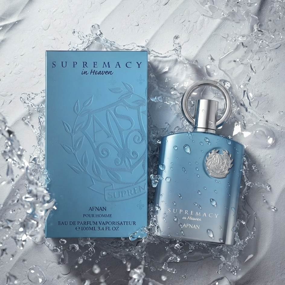 AFNAN Supremacy in Heaven Eau de Parfum for men, featuring a light blue rectangular box and a matching light blue cylindrical bottle with a silver cap, both decorated with water droplets, set against a dynamic water splash background.    SHE GLOW