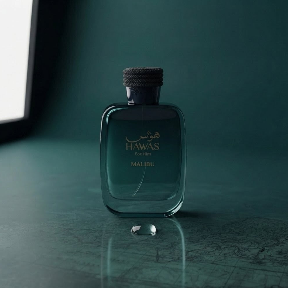 A bottle of Hawas For Men Malibu cologne in a dark teal glass bottle with a black cap, set on a dark teal surface with a small droplet in front of it. SHE GLOW ✨