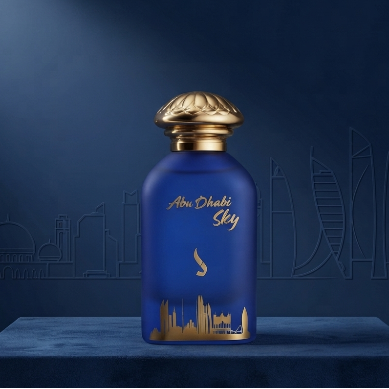 A blue perfume bottle with gold detailing and a gold cap, labeled 'Abu Dhabi Sky', displayed on a matching blue pedestal against a dark blue background with faint city skyline graphics. SHE GLOW ✨