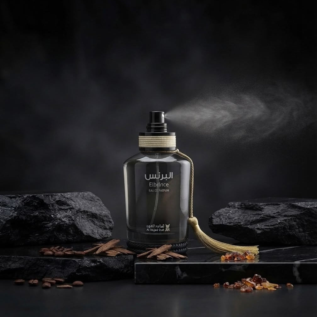 A dark glass perfume bottle labeled 'Al Rasas ESSENCE' with a gold tassel, set on a dark stone surface with scattered spices and a mist of fragrance rising behind it.        SHE GLOW ✨