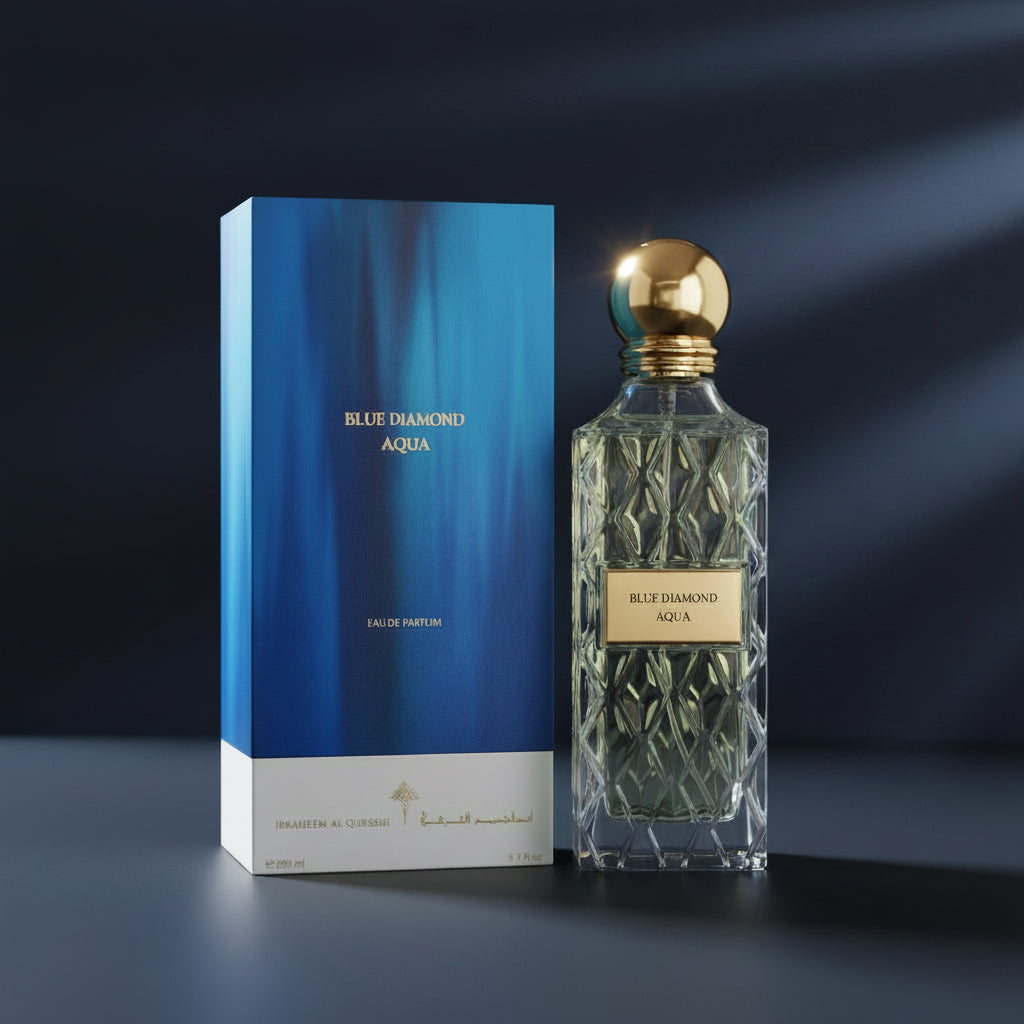 Blue Diamond Aqua Eau de Parfum bottle with a faceted clear glass body and gold cap, shown next to its blue box packaging on a white background. SHE GLOW ✨